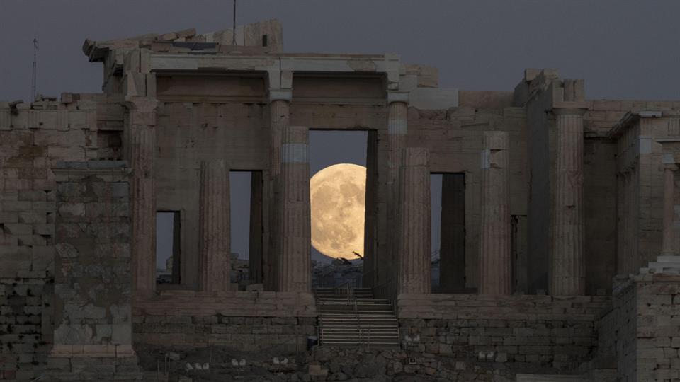 La antigua Acrópolis de Atenas, Grecia y una hermosa portal de la luna